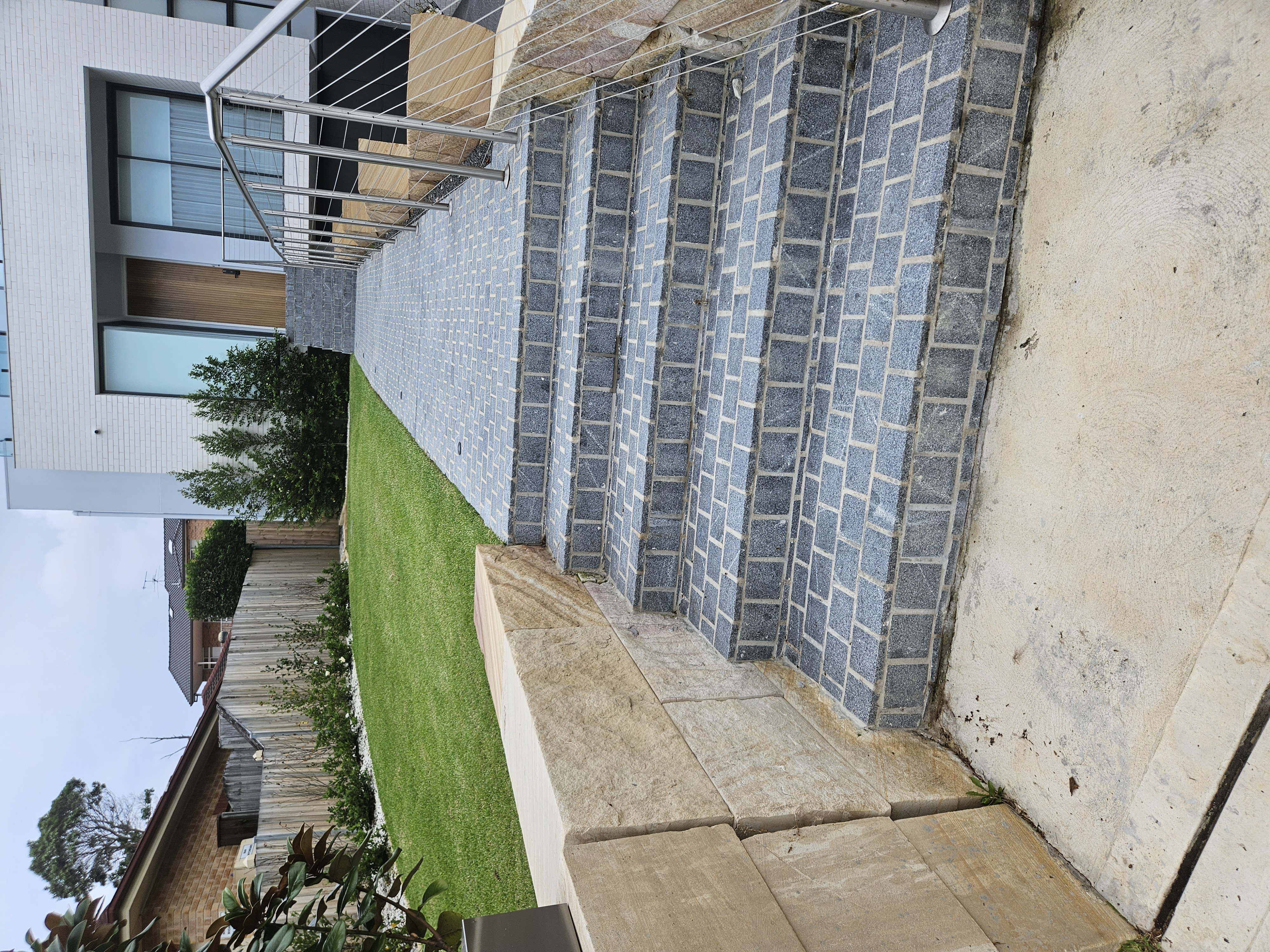 Solid sandstone block wall built alongside a stepped garden entry in Sydney