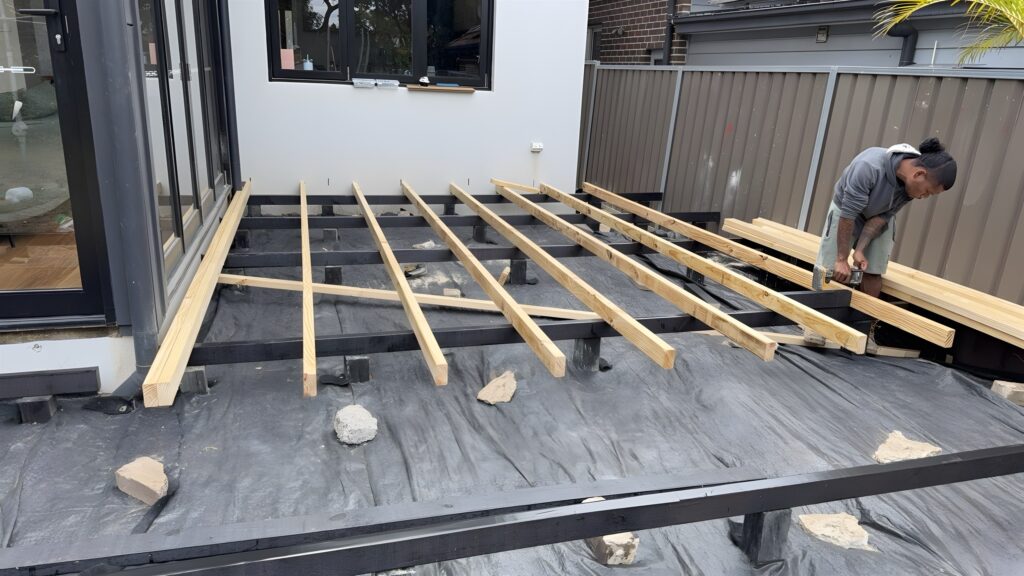 Deck bearers and joists being installed beside bi-fold doors in Five Dock