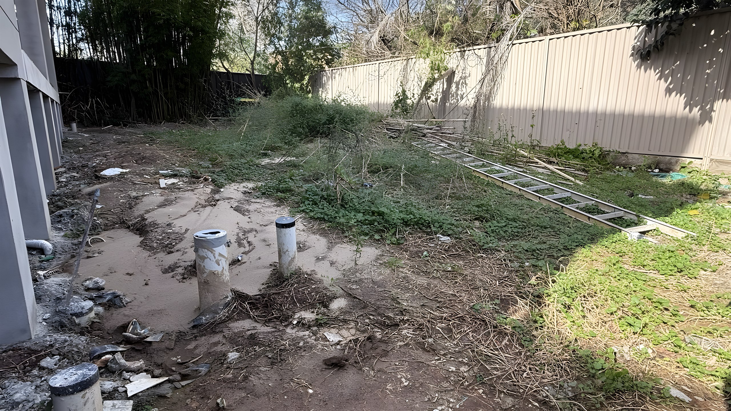 Hunters Hill backyard before landscaping with weeds and building rubble
