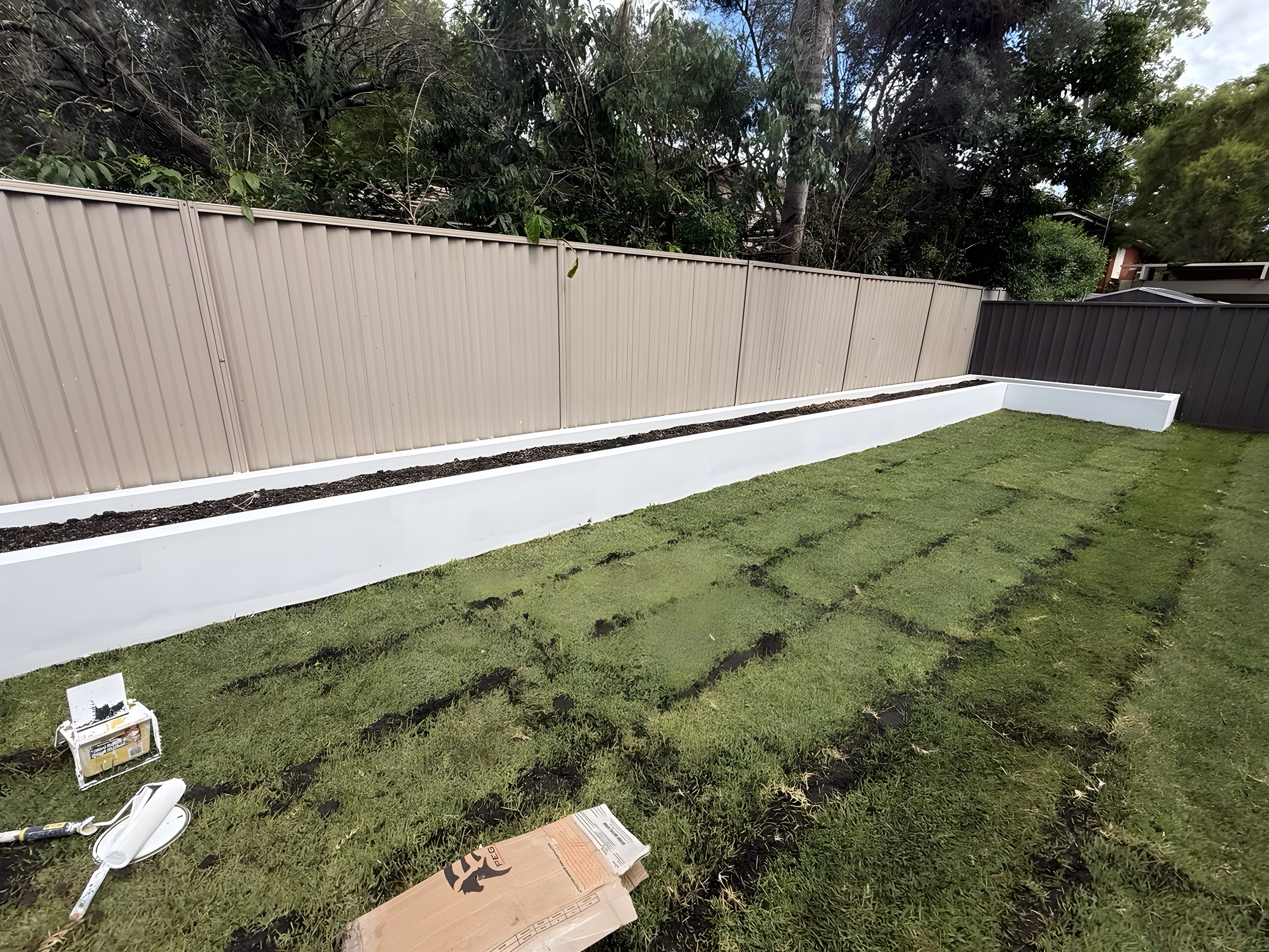 Finished front yard landscaping with rendered walls and turf at a Hunters Hill home