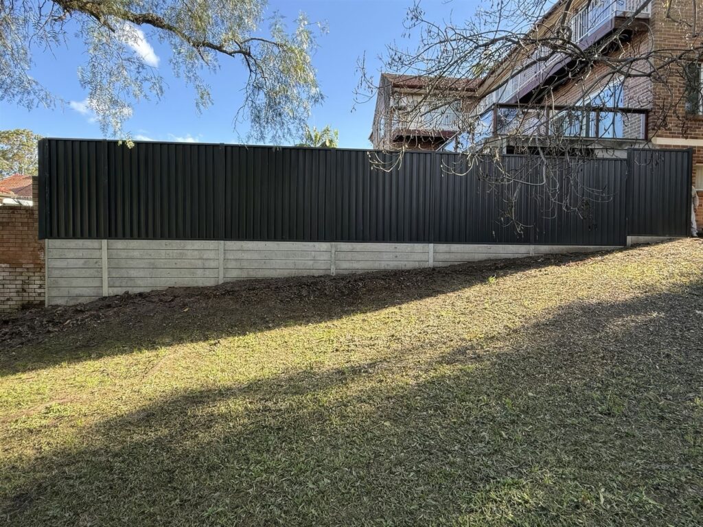 Concrete sleeper retaining wall with Colorbond fence