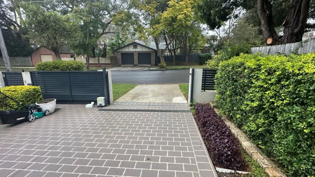 Dark slat sliding gate between brick piers