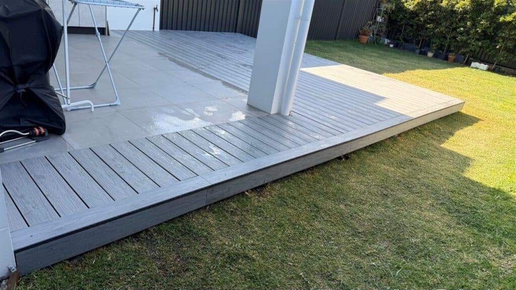 Grey composite deck at a white rendered home