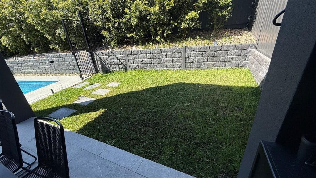 Lawn and block retaining wall beside the pool, North Sydney